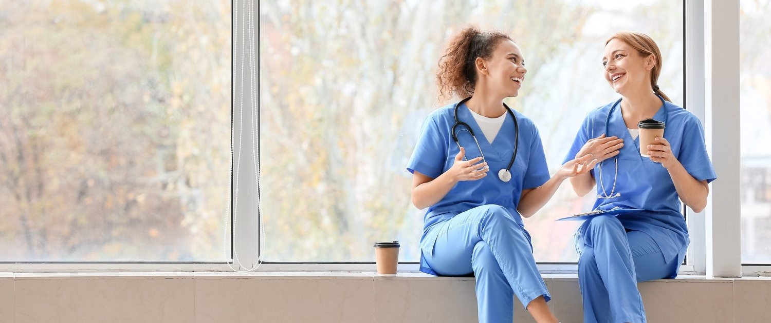 two nurses talking on a break in hallway
